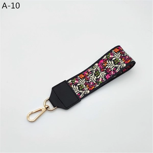 Close-up of ethnic floral embroidery handbag strap with golden metal swivel snap hooks