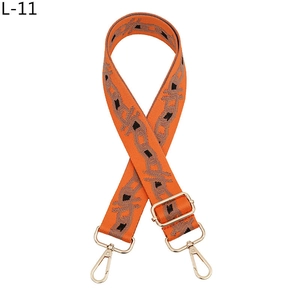 Close-up of orange woven strap with geometric pattern and gold adjustable buckle