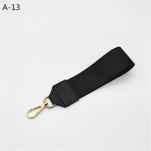 Detail of black woven hand strap with premium gold lobster clasp and stitched leather end