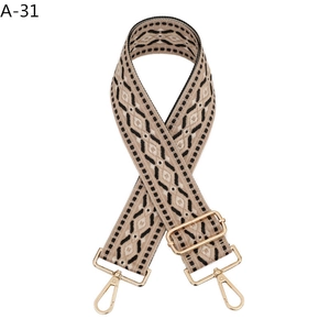 Close-up of geometric jacquard woven bag strap with adjustable light gold metal hooks