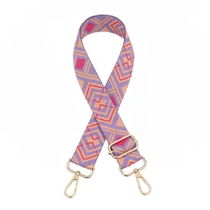 Detail of adjustable geometric woven shoulder strap with gold metal lobster clasps