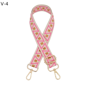 Detail of adjustable geometric woven strap with pink patterns and gold metal hooks