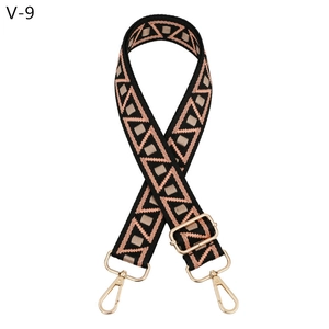 Detail of adjustable woven bag strap with geometric patterns and gold metal buckles