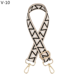 Close-up of ethnic geometric woven strap with golden lobster clasps and metal hardware