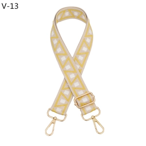 Close-up of adjustable wide bag strap with yellow geometric jacquard and gold hooks