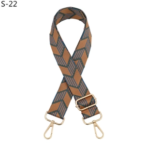 Détail de la bandoulière réglable tissée avec motifs géométriques marron et bleu et métal doré