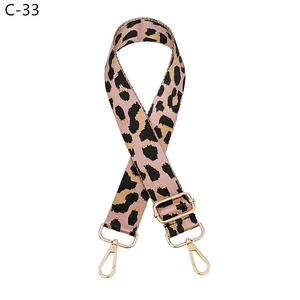 Detail view of pink leopard print jacquard strap with polished gold-tone metal hardware