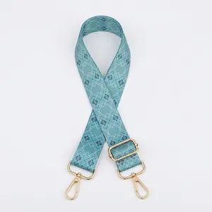 Detail view of teal geometric print bag strap with durable gold metal swivel hooks