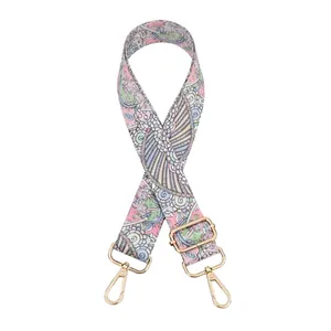 Close-up of adjustable paisley pattern bag strap with gold metal swivel snap hooks