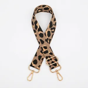 Detail of leopard print bag strap with golden metal hooks and adjustable buckle