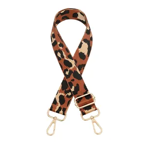 Detailed view of leopard print canvas bag strap with golden metal swivel hooks and adjuster