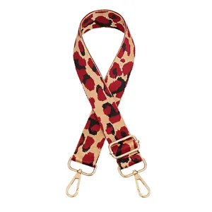 Close-up of wide leopard print bag strap with gold metal hardware and red pattern details