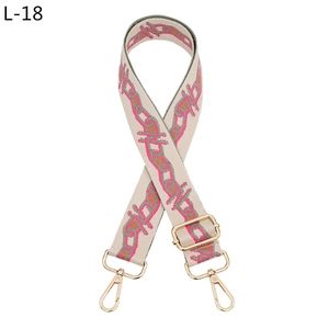 Detail of woven geometric pattern bag strap with gold metal hooks and adjustable buckle