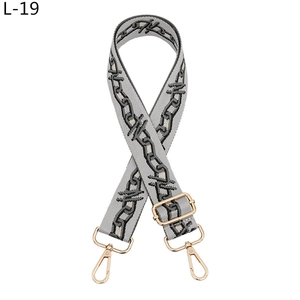 Macro detail of grey woven replacement bag strap with golden metal swivel hooks and buckles