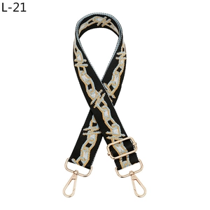 Detail of woven replacement handbag strap in black, blue and gold with metal lobster clips