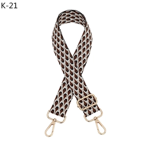 Detail of adjustable geometric strap with tan teardrop patterns and light gold hooks