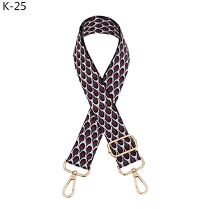 Detail of red, grey, and blue woven bag strap with golden lobster clasps and buckle