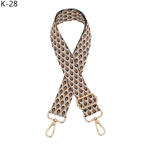 Close-up of adjustable woven shoulder strap with leopard geometric pattern and gold buckles