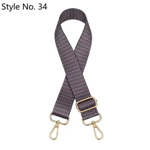 Macro detail of adjustable ethnic style bag strap with gold lobster clasps and geometric patterns