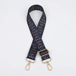 Detail of adjustable blue ethnic floral strap with gold metal buckle and swivel hooks