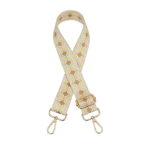 Detail of adjustable geometric diamond pattern bag strap with gold metal hooks
