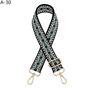 Detail of green and beige diamond pattern woven strap with gold lobster clasps
