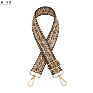 Close-up of geometric diamond weave bag strap with golden metal swivel hooks