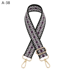 Detail of adjustable woven shoulder strap with purple geometric pattern and gold hardware