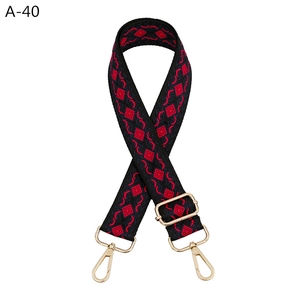 Detail of adjustable geometric diamond pattern bag strap with golden metal lobster clasps