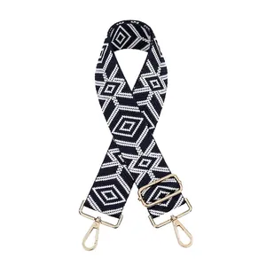 Close-up of black and white diamond pattern canvas strap with gold metal hardware