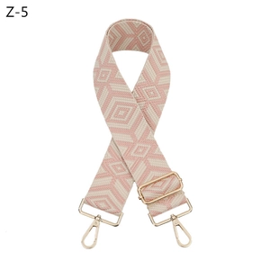 Detail of pink and cream diamond jacquard bag strap with polished gold lobster clasps