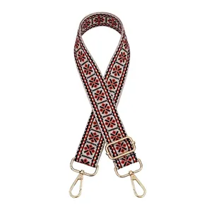 Close-up of ethnic geometric pattern strap with golden metal swivel hooks and buckles
