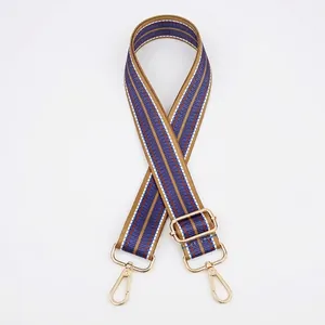Detail of adjustable geometric blue and brown handbag strap with gold metal hardware