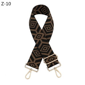 Macro view of adjustable woven shoulder strap with geometric diamond patterns and gold buckles