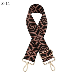 Detail of adjustable woven bag strap featuring a pink and gold diamond geometric pattern