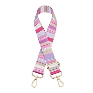 Detail view of the colorful striped woven bag strap with adjustable gold-tone metal buckles