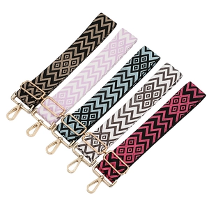 Detail of adjustable jacquard wide shoulder straps with golden metal hooks and geometric patterns