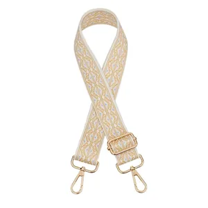 Close-up of ethnic geometric pattern bag strap with polished gold-tone metal hooks