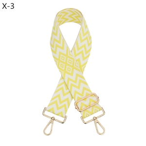Detail of yellow and white jacquard bag strap with light gold metal lobster clasps