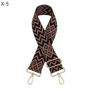 Detailed view of wide jacquard bag strap with geometric diamond pattern and gold hooks