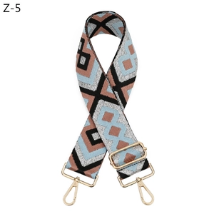 Close-up of geometric jacquard shoulder strap with gold-tone hardware and buckle