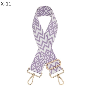 Detail of adjustable purple and white geometric jacquard bag strap with gold metal hooks