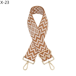 Close-up of brown and white jacquard diamond pattern bag strap with gold metal swivel hooks