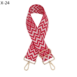 Macro shot of red and white geometric jacquard bag strap with gold metal lobster clasp