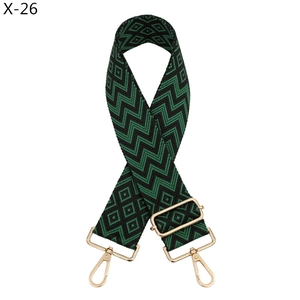 Detail of adjustable black and green jacquard wide bag strap with gold metal hooks