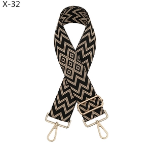 Detail of adjustable geometric jacquard bag strap with gold metal hooks and wave pattern