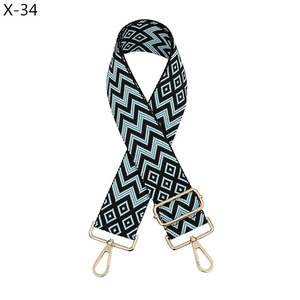 Detail of blue and black jacquard woven diamond pattern strap with gold metal hooks