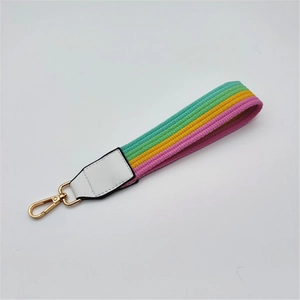 Macro shot of colorful rainbow striped braided wrist strap with gold metal clasp hook