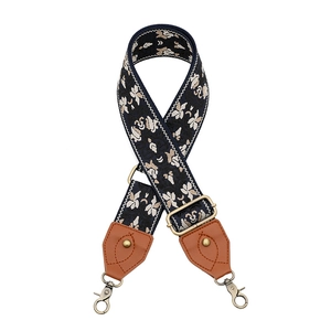 Detail der floralen Stickerei am dunkelblauen Taschenriemen mit bronzenen Karabinerhaken