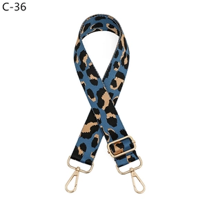 Detail of adjustable leopard print bag strap with golden hardware and dense weave texture